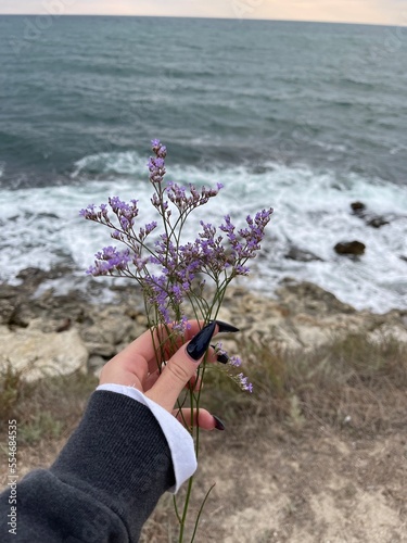 hand holding flowers sea