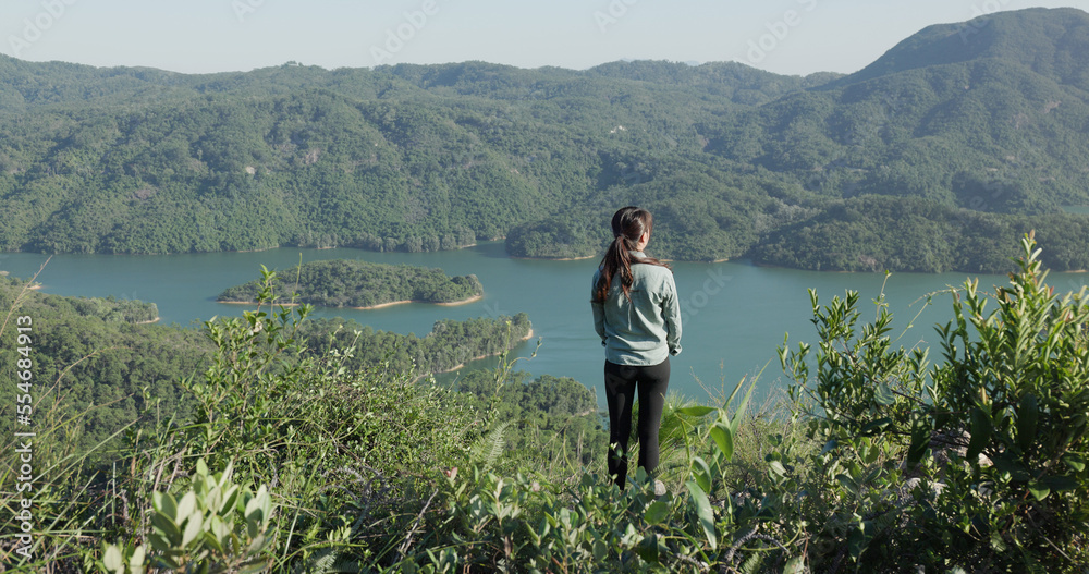 Woman go hiking and stand at the top of mountain Woman go hiking and stand at the top of mountain