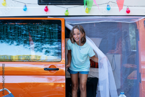 The girl has fun on a wonderful day at camp. Van life concept.