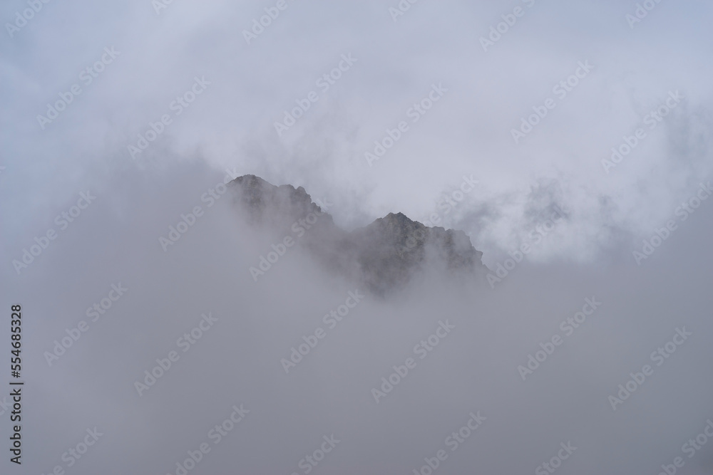 Rocky mountain peaks come out of the clouds, Maira Valley, Italian Cottian Alps