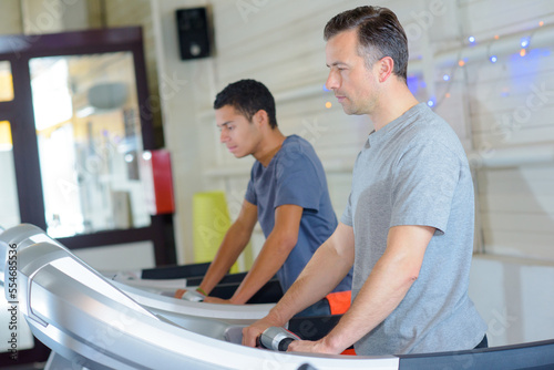Two men on exercise machines