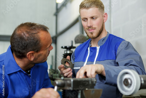 two male engineers working together in factory © auremar