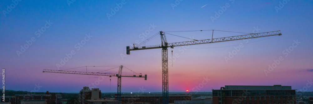 Panorama Construction Crane over college campus with sunset dawn blue red purple skyline