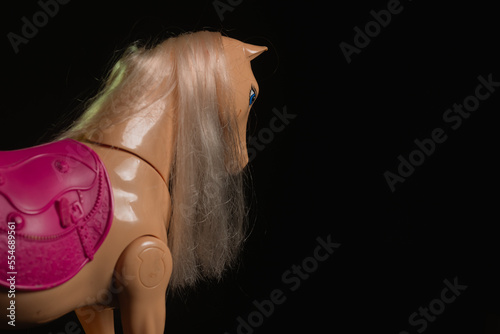 Black toy horse isolated on black background