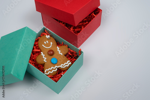 Christmas gingerbread man cookie in green box and on white background, surprise cookies in gift box 