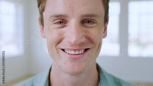 Face, man and smile for happiness, kindness and humanity while in a bright room showing perfect teeth for dental marketing. Portrait of friendly London male with freckles, happy and positive mindset photo