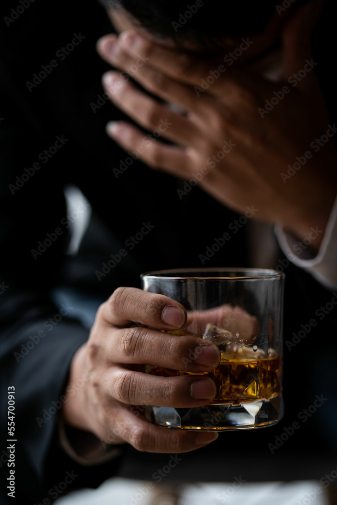 Alcoholism concept. Young man drinking alcohol too much.Stressed drunk man sitting alone with glass of whiskey in bar Drunk man with glass and bottle of alcohol drink sitting at table