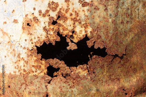 Old steel broken tank hole from rust close up.
