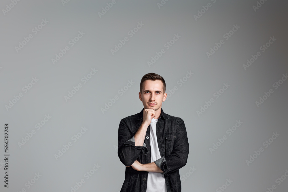 thoughtful man holding arms folded, touching chin with hand thoughtful man holding arms folded, touching chin with hand