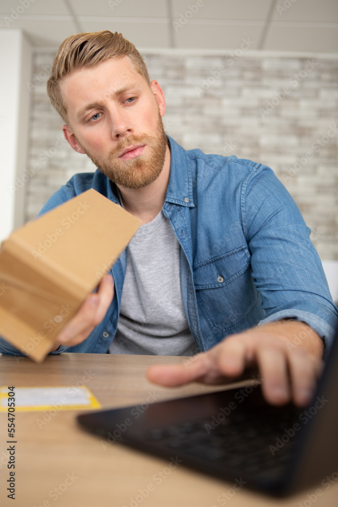man with laptop and cardboard box at home man with laptop and cardboard box at home