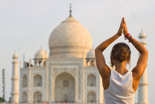 Girl doing yoga in front of the Taj Mahal. Tree pose. photo