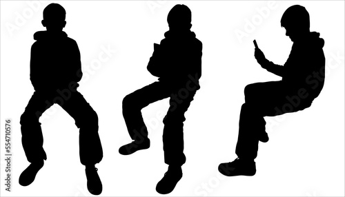 A group of teenagers is texting on a phone. Silhouette of a schoolboy with a cell phone. A young man with a mobile phone in his hand. The teenager is sitting. A set of black silhouettes are isolated