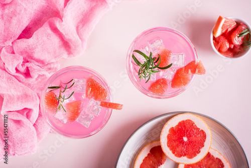 Pink cocktail with rosemary in glasses on the table. Pink food concept. Top view