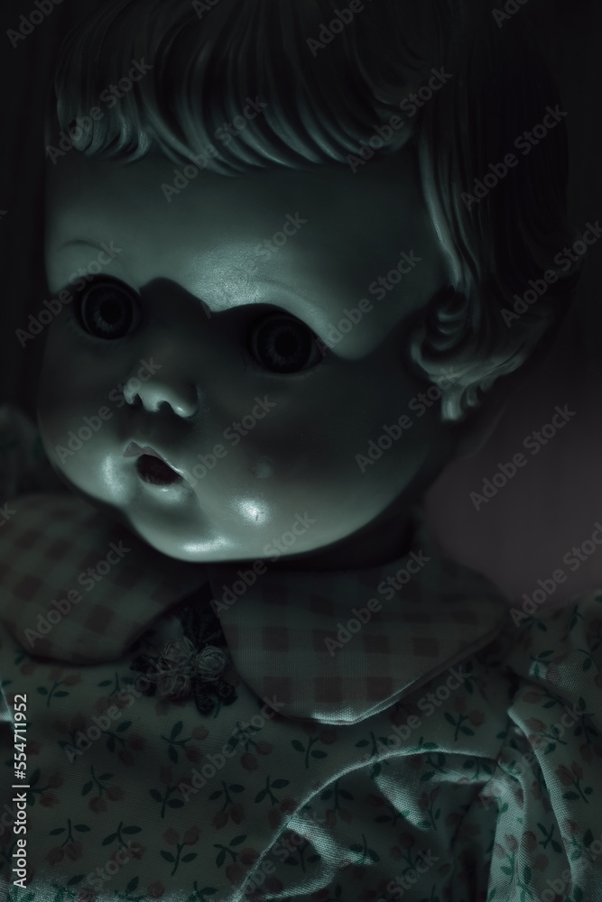 Spooky green light and shadows over an antique doll's eyes in a dark room. Spooky green light and shadows over an antique doll's eyes in a dark room.