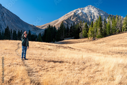Hiker stops along a trail to point at something © knowlesgallery