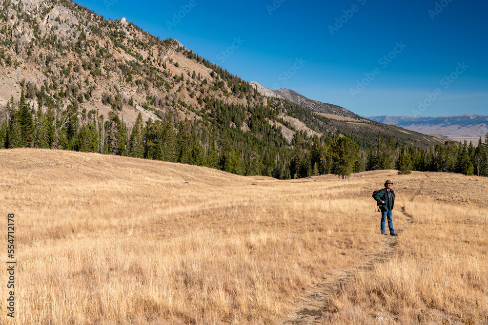 Hiker stops along a trail to take in the view