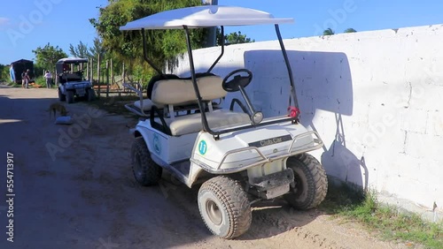 Golf cart buggy cars carts muddy street village Holbox Mexico.