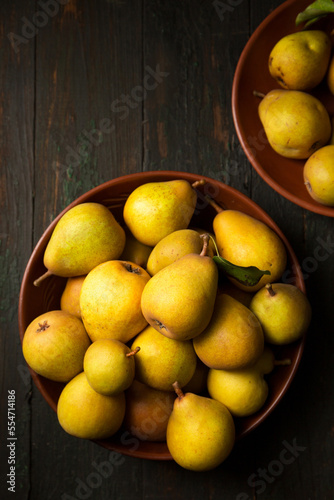 Delicious juicy pears in clay plates in rustic style.