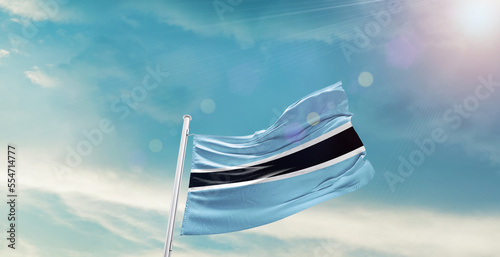 waving flag of Botswana in blue sky. the symbol of the state on wavy cotton fabric.