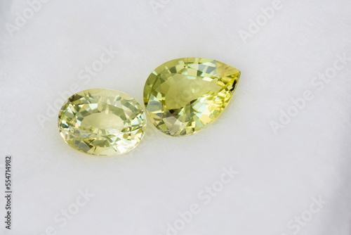 Natural bright lemon yellow color chrysoberyls drop and oval shaped faceted loose gemsotnes. Settings for jewelry making. Unheated, untreated, earth mined. 
white cotton background. Gemology theme.
