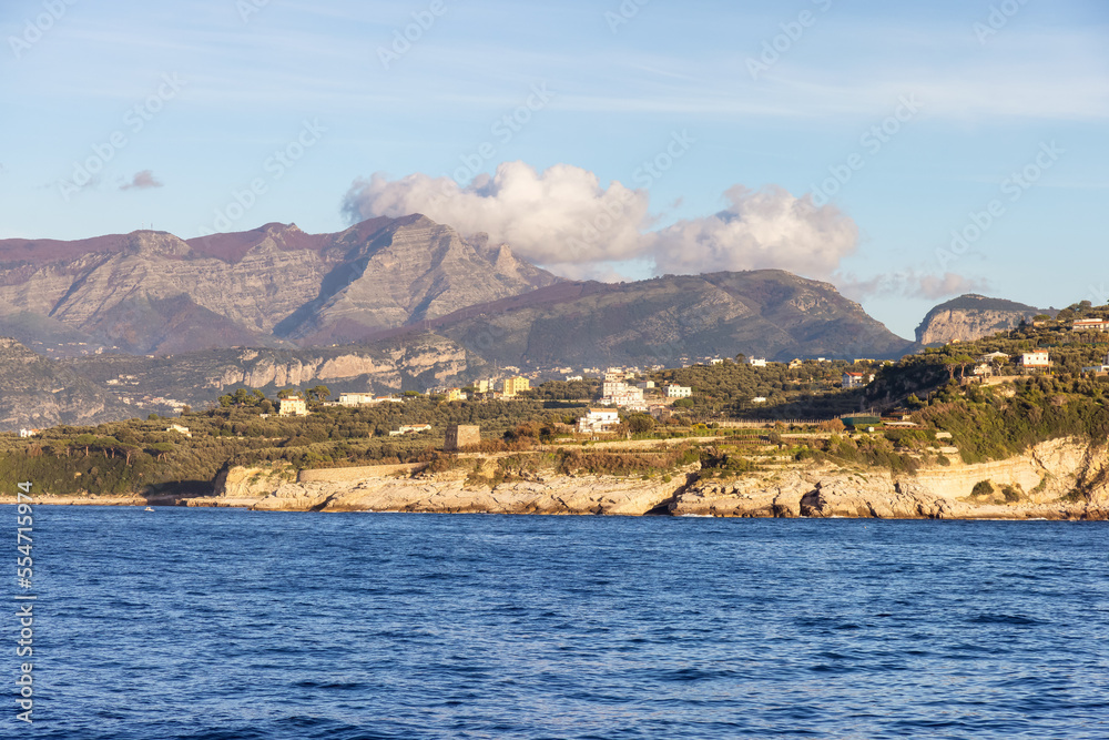 Fototapeta premium Rocky Coast and Homes near Touristic Town, Sorrento, Italy. Amalfi Coast. Sunny Evening