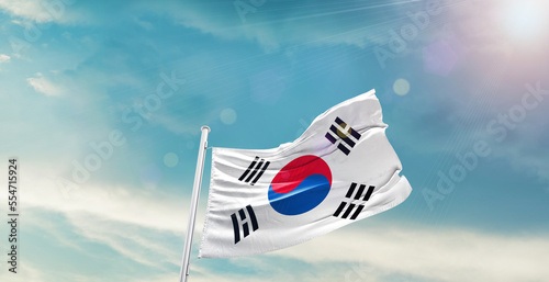 waving flag of South Korea in blue sky. the symbol of the state on wavy cotton fabric.