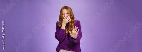 Oh gosh how stink take away, gross. Portrait of disgusted and displeased redhead woman pulling hand towards camera in rejection gesture while closing nose not smell awful reek squinting from aversion