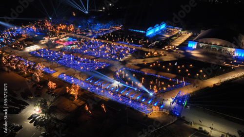 Aerial drone night distant shot from illuminated with Christmas lights futuristic Ellinikon Experience public Park an urban regeneration project and cultural center in Athens riviera, Attica, Greece