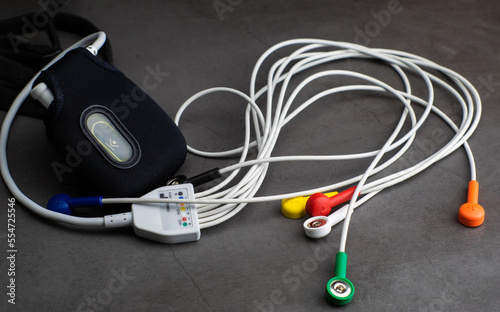 Obraz na płótnie Holter, a medical blood pressure monitor for a heart rate measurement with all the colorful cables on industrial gray background w salonie