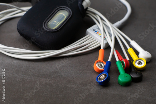 Holter, a medical device for a heart rate measurement with all the colorful cables on industrial gray background photo