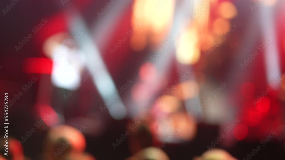 Illuminated and blurry dancing crowd at a concert. Silhouette of people at a party during the concert. People wave their hands, greeting their musician, singer. Illuminated and blurry dancing crowd at a concert. Silhouette of people at a party during the concert. People wave their hands, greeting their musician, singer.