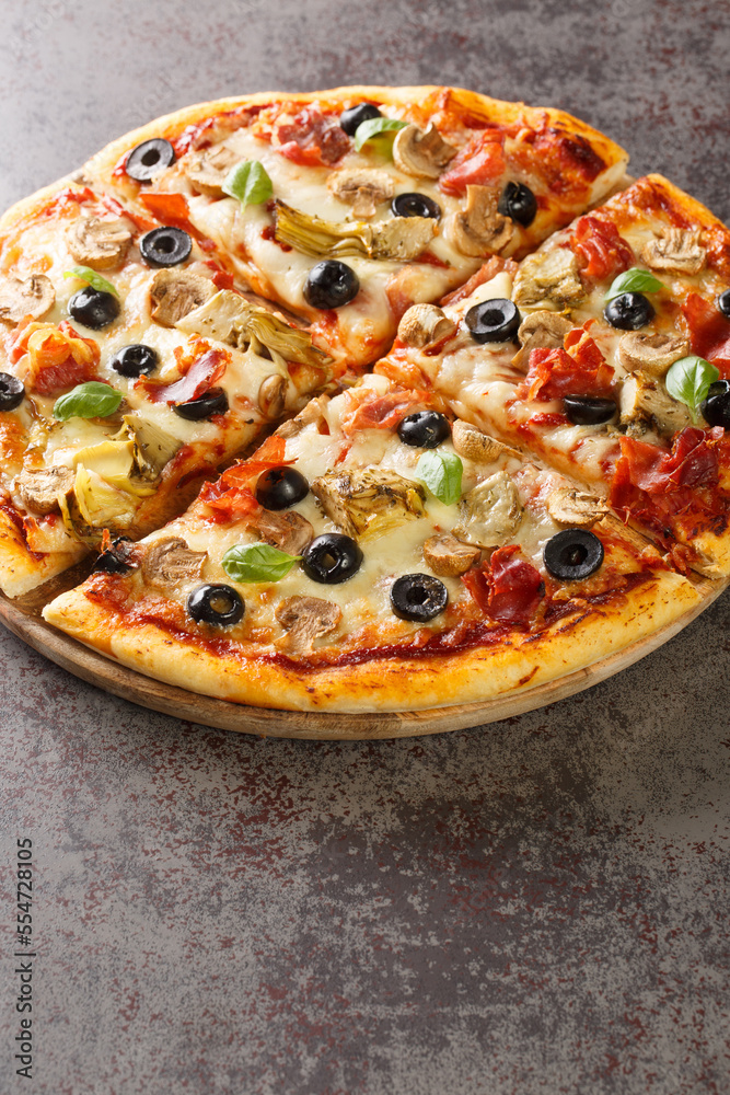 Italian cuisine Pizza capricciosa prepared with mozzarella cheese, ham, mushroom, artichoke, tomato and olive closeup on the wooden board on the table. Vertical