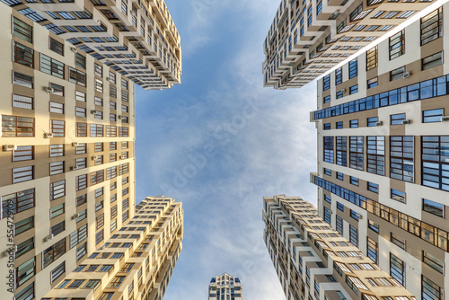 Tableau sur toile view up from ground to blue sky among skyscrapers, look at house from bottom up