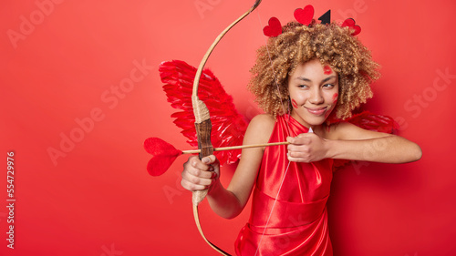 Foto Mysterious woman cupid with wings behind back being God of love makes couple mee