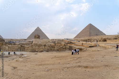 The sphinx with the pyramids of Kefren and that of Giza behind, in an afternoon with some clouds in the sky. photo