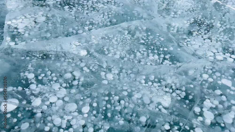 Frozen methane bubbles and cracks in the ice on Lake Baikal Siberia Russia. Natural cold background of ice. Winter abstract background. High quality 4k footage