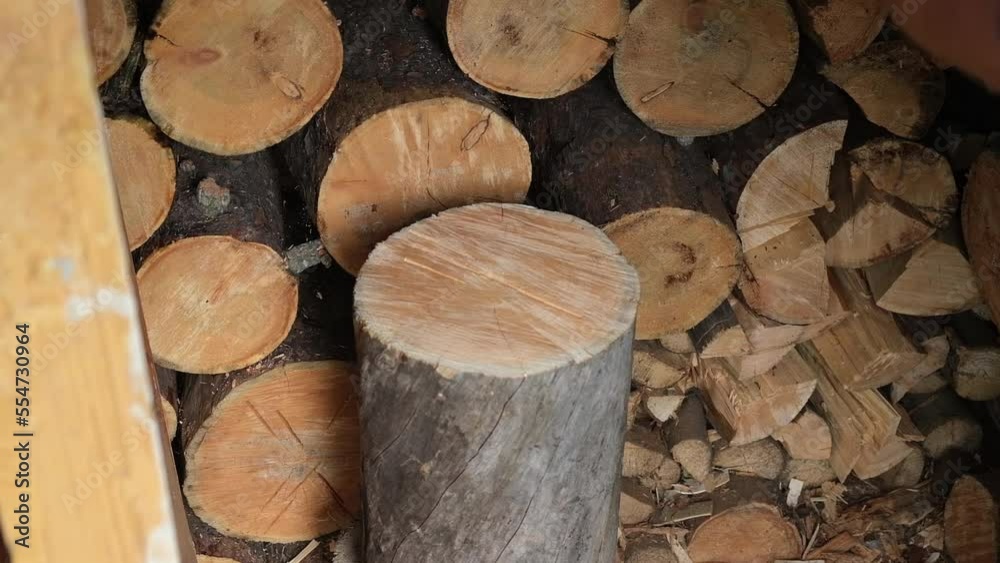 A man is chopping logs with an axe on chopping block. Harvesting of firewood stocks for heating. An alternative source of thermal energy instead of natural gas. A man is chopping logs with an axe on chopping block. Harvesting of firewood stocks for heating. An alternative source of thermal energy instead of natural gas.