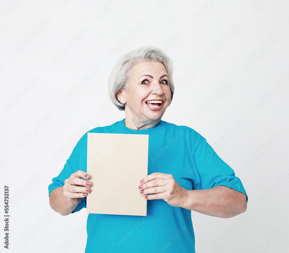 Portrait of happy senior woman wearing blue tshirt with blank advertising board or copy space Portrait of happy senior woman wearing blue tshirt with blank advertising board or copy space