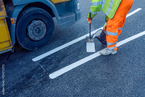 Quadro em tela Road workers applying hot melt traffic resistant paint for white, yellow and red