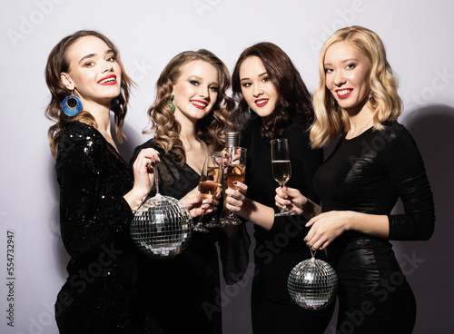 Young sensual women wearing evening dress and holding disco balls
