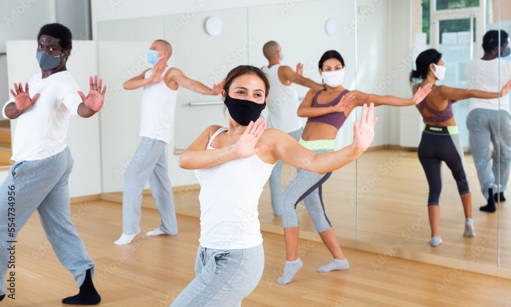 People in protective masks learning swing steps at class