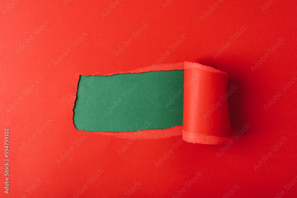 Obraz premium Hole in red paper on green background. Mockup