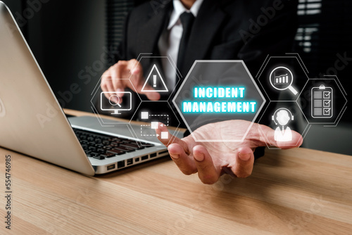 Incident Management process Business Technology concept, Business person hand holding incident management icon on virtual screen. photo