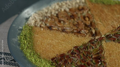 Traditional Turkish dessert kunefe in the copper plate. Kanafeh concept with cheese and pistachio 
 photo