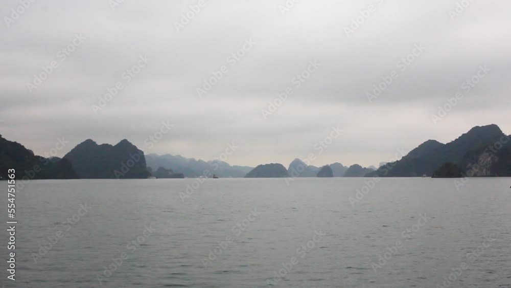 Cruising in halng bay with the rocks in the background on a foggy morning Cruising in halng bay with the rocks in the background on a foggy morning