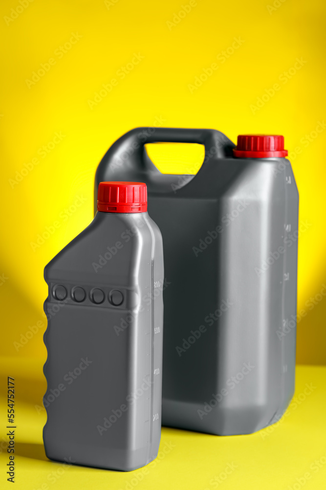 Canister and bottle of car products on yellow background Canister and bottle of car products on yellow background