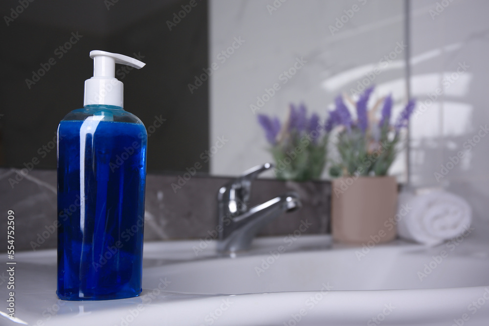 Bottle of shower gel on sink in bathroom. Space for text