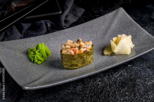 Sushi gunkan with spicy eel on dark table
