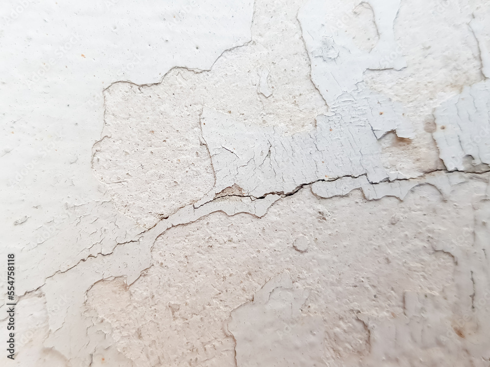Close-up of the cracks and peeling paint on the walls of the house.