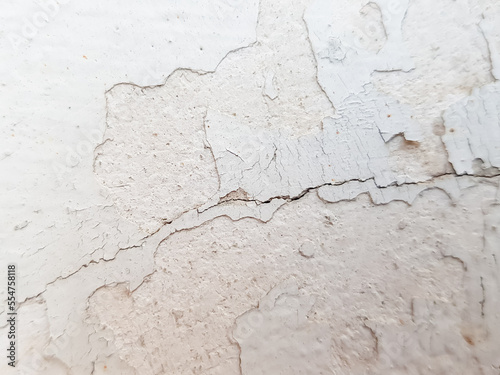 Close-up of the cracks and peeling paint on the walls of the house.